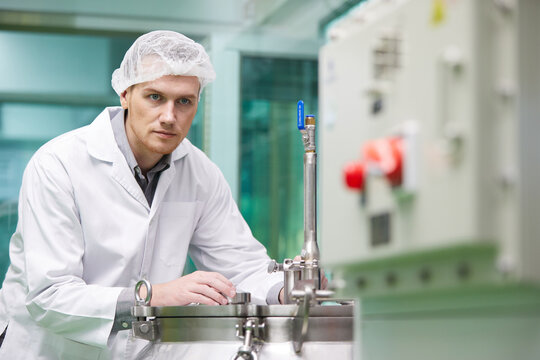 Scientist Operating Control Panel With Cannabis Extraction Machines In Testing Lab