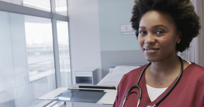 Portrait of happy african american female doctor in hospital room with copy space, slow motion