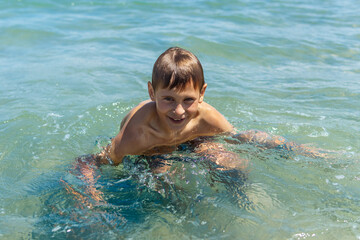 Happy boy swims and dives underwater. water sports and activities with parents on summer