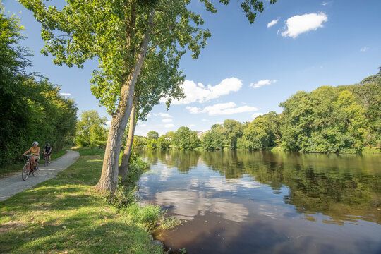Un couple &agrave; velo sur le parcours velo Francette entre chateau Gontier sur Mayenne et Angers en region Pays de la Loire, le long de la riviere mayenne.  Vue en pleine nature sous un ciel bleu en &eacute;t&eacute;.