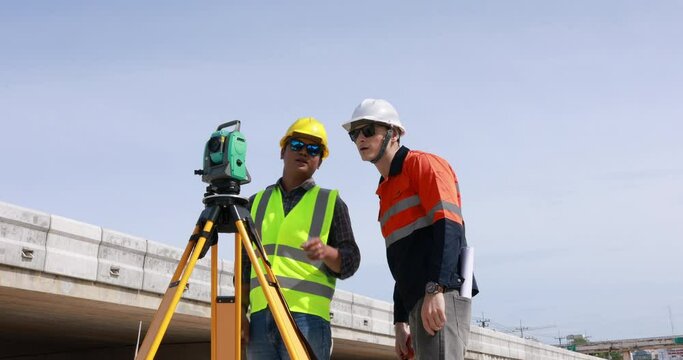 Engineer use theodolite equipment for route surveying to build a bridge across the intersection to reduce traffic congestion during rush hours. 
