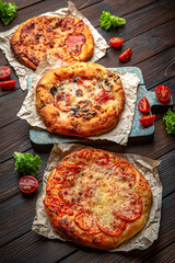 Three mini pizzas on brown boards. Bakery products. Fresh bakery.