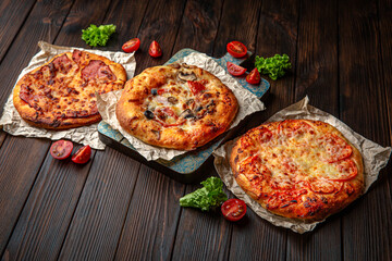 Three mini pizzas on brown boards. Bakery products. Fresh bakery.