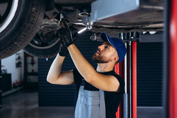 Auto mechanic lifting car and doing check up on car service