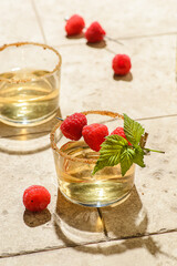 the cocktail is decorated with raspberries