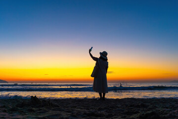 Fototapeta premium Sunrise at My Khe beach, Danang, Vietnam. Da Nang locals and tourists exercise along Da Nang beach, silhouette people walking seaside, relaxing, jogging on beach