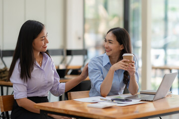 Two happy asian businesswoman talking and consulting working together in the office