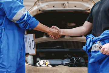 Auto mechanic handshake successful colleague in auto service center To congratulate the success of car maintenance. Professional car mechanic shaking hands.