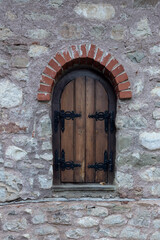 The background old beige stony wall with a window