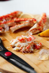 Crab meat. on a wooden board with scissors.