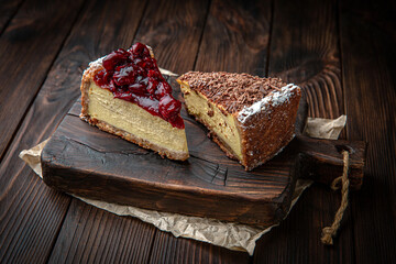 Cheesecake with cherry jam and chocolate chips on brown boards. Bakery products. Fresh bakery.