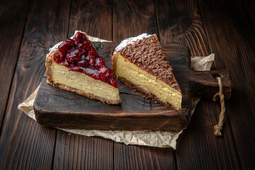 Cheesecake with cherry jam and chocolate chips on brown boards. Bakery products. Fresh bakery.