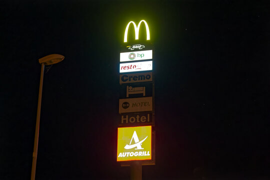 Illuminated advertising signs Highway restaurant Rose de la Broye at Village de Lully by night. Photo taken June 7th, 2023, Lully, Switzerland.
