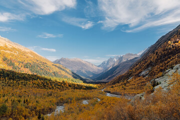 Valley with mountains and autumnal forest. Mountain landscape with river