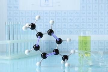 Molecular model and laboratory equipment on light surface