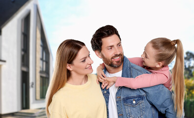 Portrait of happy family with child near house