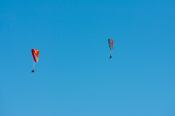 paraglider couple flying with a blue sky