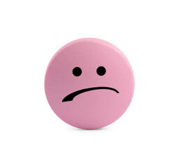 Pink pill with sad face on white background