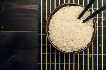 Basmati rice bowl with chopsticks on bamboo placemat