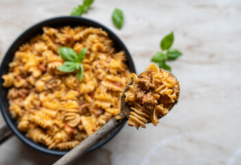 Creamy beef and pasta on a wooden spoon. Top view with copy space