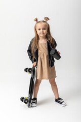Stylish little girl child with skateboard over white background, Space for advertising