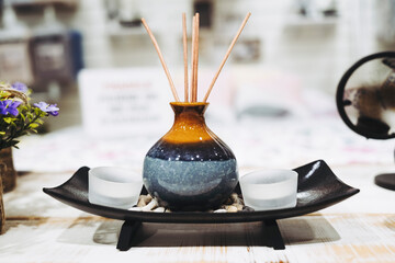 B&acirc;tonnets d&eacute;sodorisant dans un petit vase en c&eacute;ramique dans une coupelle - Ambiance int&eacute;rieure de maison zen