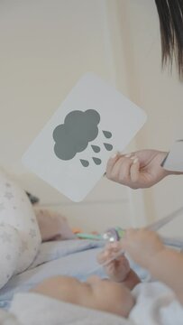 Woman playing with baby daughter on bed