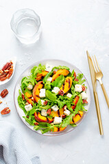 Grilled Peach Salad with Blue Cheese, Pecans and Arugula on Bright Light Blue Background