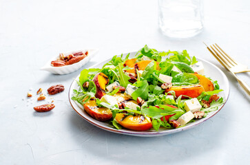 Grilled Peach Salad with Blue Cheese, Pecans and Arugula on Bright Light Blue Background