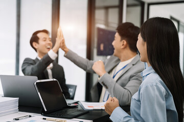 Group of Young Asian business team creative businesspeople coworker in office Happy to be successful partnership teamwork success concept.