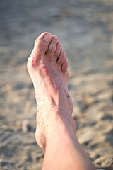 male feet, male foot on the beach in the sun