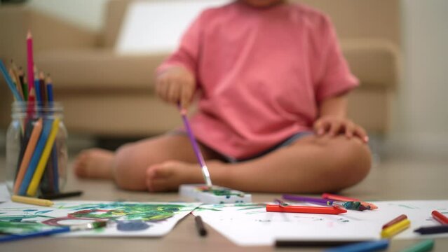Close up shots paint brushes of Little cute girl creating and water color painting activity in living room at home. Kids activity. Child physical, Emotional, Cognitive development concept.