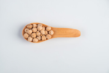 Chickpeas source of natural protein, vitamins and minerals. Healthy diet food in wooden spoon. white background.