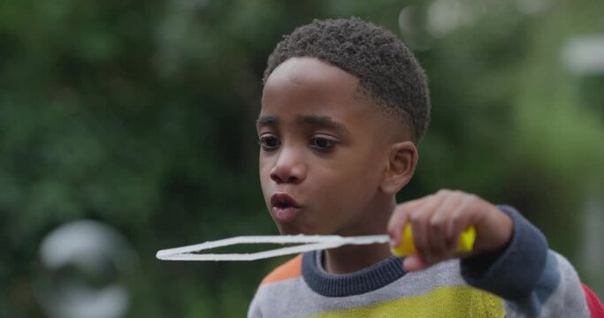 Close-up of boy blowing bubbles in garden
