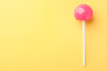 One tasty lollipop on yellow background, top view. Space for text