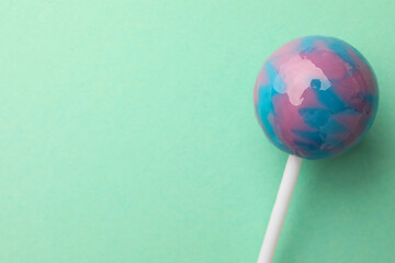Tasty lollipop on turquoise background, top view. Space for text