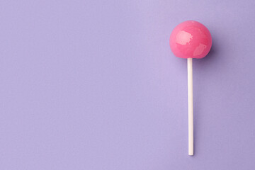 Tasty lollipop on violet background, top view. Space for text