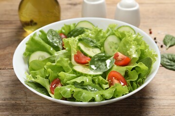Delicious salad in bowl on wooden table, closeup