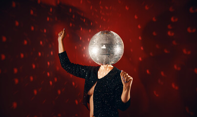 Woman in sequin dress with disco ball instead of head dancing at a party