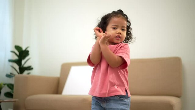
Happy moment little cute dancing activity with music in living room at home. Kids activity. Child physical, Emotional, Cognitive development concept.
