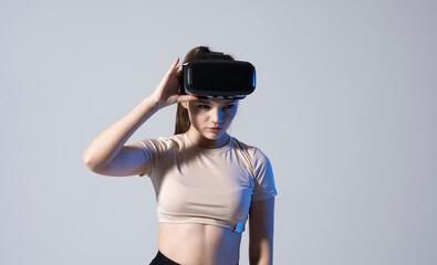 Portrait of young brunette woman gamer with virtual reality headset on a head.