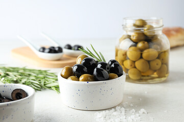 Olives in bowls and jar on white background, close up