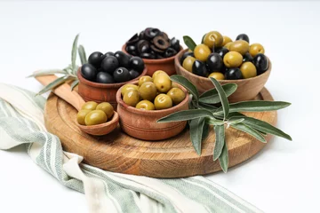 Foto op Plexiglas Olives in bowls and spoon on wooden stand on white background, close up © Atlas