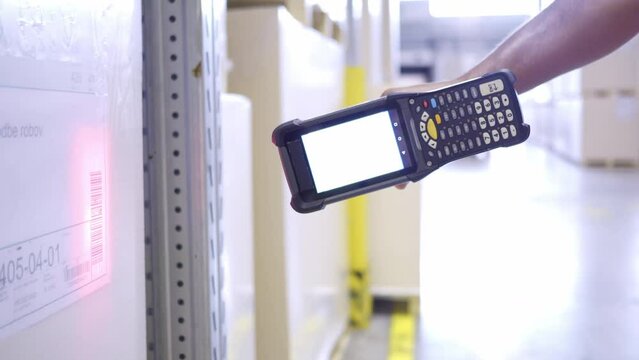 Warehouse employee using barcode scanner device while managing stock inventory closeup. Shipment manager scanning goods with handheld bar code reader in storehouse