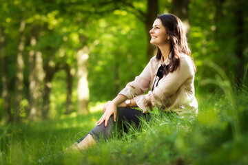 Young woman is sitting relaxed and balanced on a meadow
