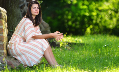 Young woman sitting in harmony against a brick wall