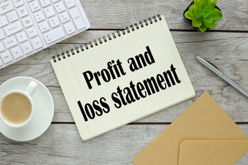 PROFIT AND LOSS STATEMENT cup of coffee near notepad with text and white keyboard