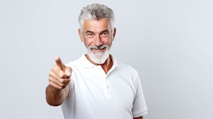 Senior man pointing and smile at the camera, showing funny laugh expression. White shirt and gray background, studio shot. Generative AI