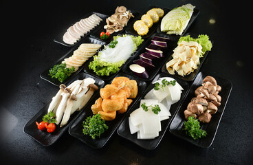 cold mixed raw vegetables,  beancurd, mushroom, carrot, noodle, tofu, lotus, corn in plate for steam boat hot pot ingredient on black marble table asian halal food cuisine menu for restaurant
