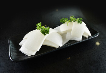 cold mixed raw vegetables,  beancurd, mushroom, carrot, noodle, tofu, lotus, corn in plate for steam boat hot pot ingredient on black marble table asian halal food cuisine menu for restaurant